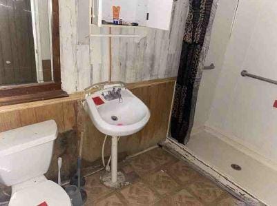 11114 E State Highway 31, Kerens, TX 75144 - full bath with a shower stall, toilet, and wooden walls