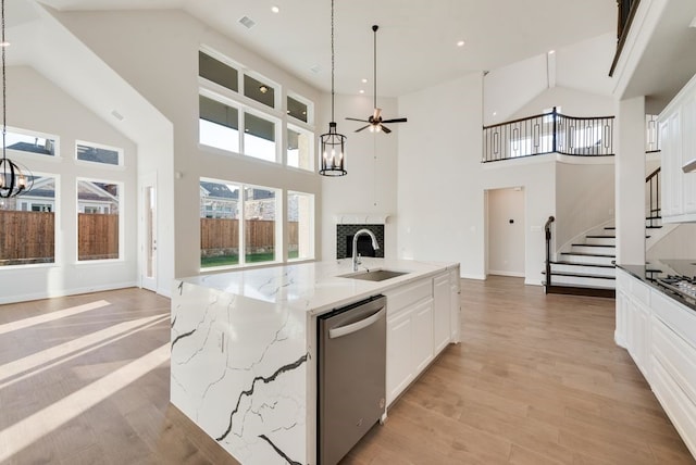 kitchen with sink, decorative light fixtures, dishwasher, white cabinetry, and a large island