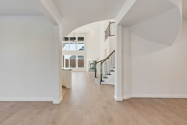 entryway featuring light wood-type flooring and a towering ceiling