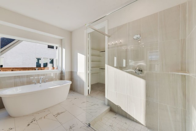 bathroom featuring separate shower and tub and tile walls