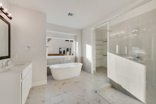 bathroom featuring a tub to relax in, vanity, and tile walls