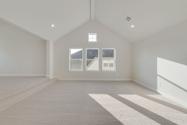 unfurnished room featuring beamed ceiling, light colored carpet, and high vaulted ceiling