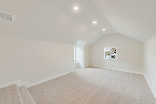 bonus room featuring lofted ceiling and light carpet