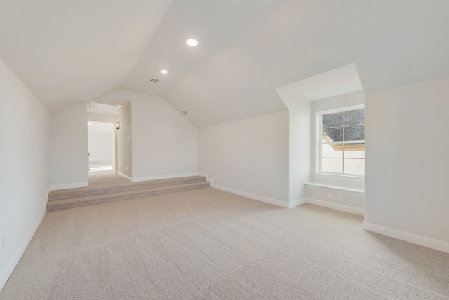 bonus room with light carpet and vaulted ceiling