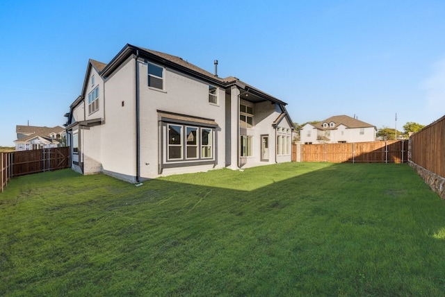 rear view of house featuring a lawn