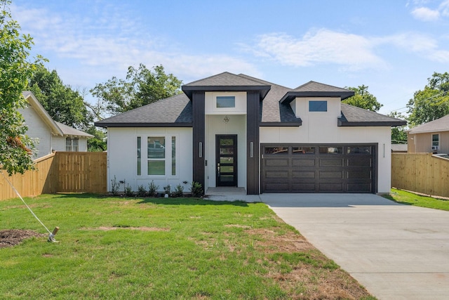 view of front of property featuring a front yard and a garage