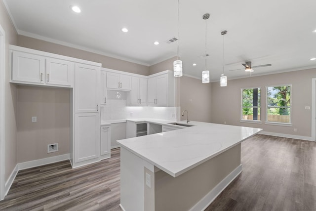 kitchen with white cabinetry, sink, ceiling fan, light stone counters, and pendant lighting