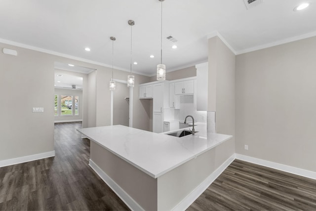 kitchen featuring kitchen peninsula, sink, decorative light fixtures, dark hardwood / wood-style floors, and white cabinetry