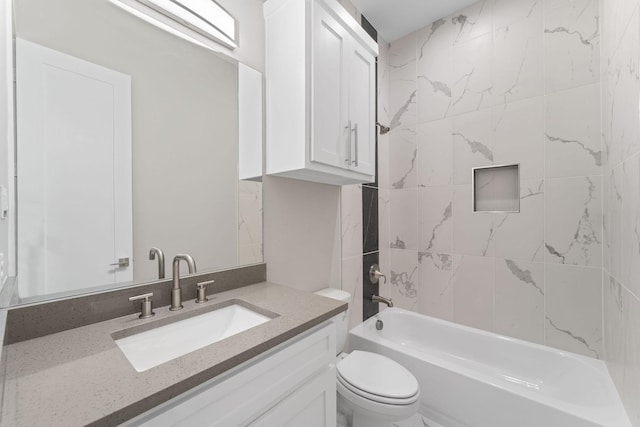 full bathroom featuring tiled shower / bath, vanity, and toilet