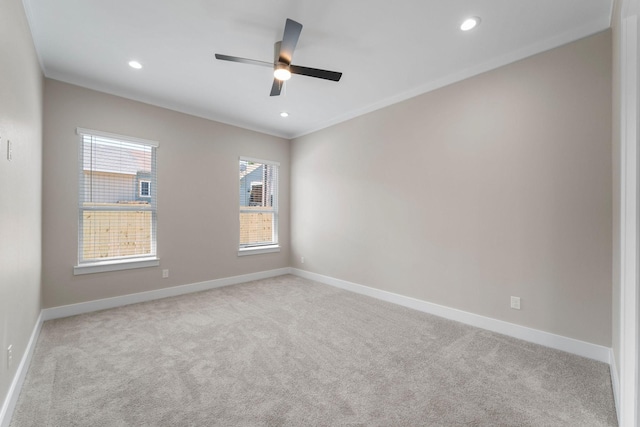 carpeted spare room with ceiling fan and crown molding