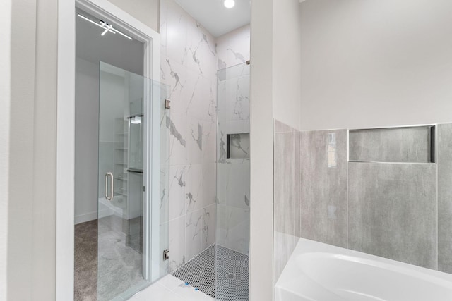 bathroom with tile patterned flooring and separate shower and tub