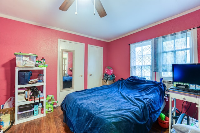 bedroom featuring crown molding, dark wood-type flooring, and ceiling fan