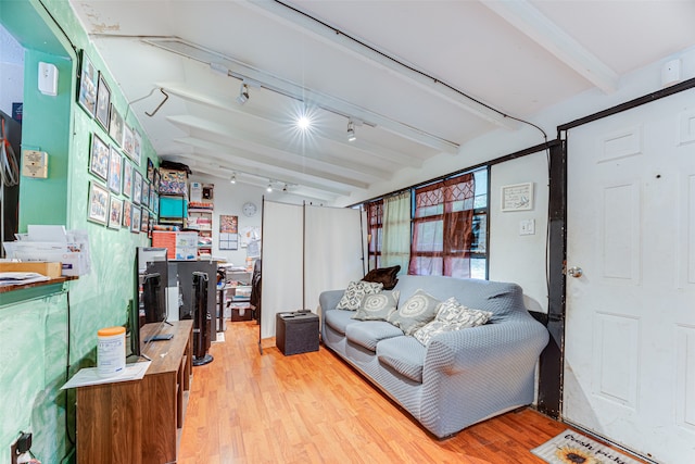 living room featuring beamed ceiling, track lighting, and light hardwood / wood-style floors