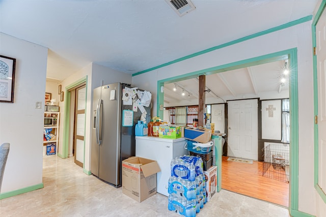 kitchen with vaulted ceiling with beams, light hardwood / wood-style flooring, and stainless steel fridge with ice dispenser