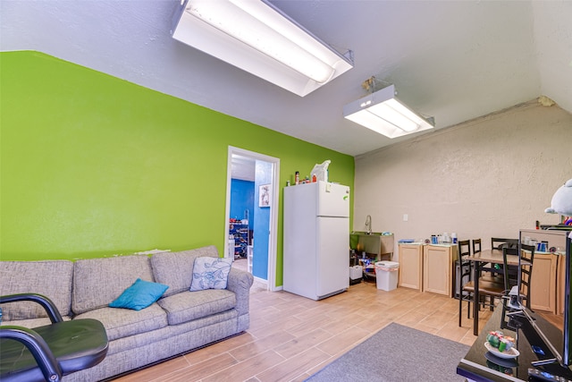 living room with lofted ceiling and light wood-type flooring