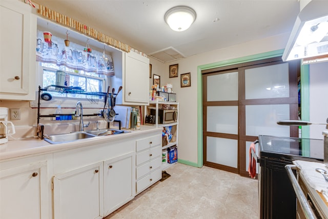 kitchen with white cabinetry, electric range oven, and sink