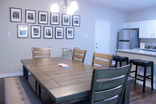 dining room with dark wood-type flooring and an inviting chandelier