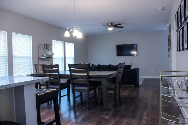 dining room featuring ceiling fan with notable chandelier and dark hardwood / wood-style flooring