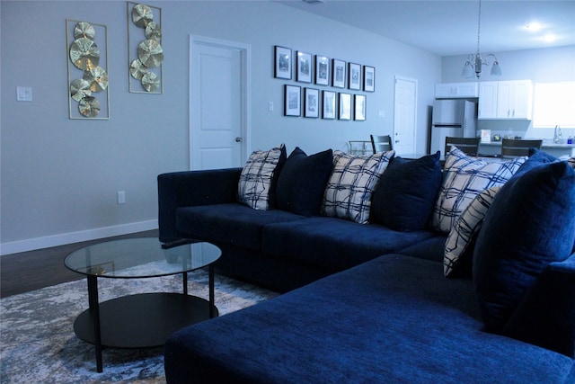 living room featuring hardwood / wood-style flooring, a chandelier, and sink