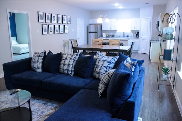 living room featuring hardwood / wood-style flooring, sink, and a chandelier