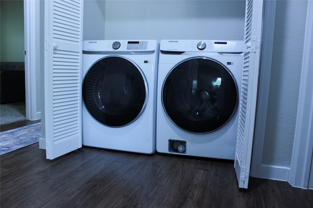 clothes washing area with dark hardwood / wood-style flooring and washing machine and clothes dryer