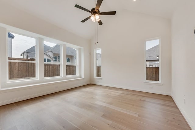 spare room with light wood-type flooring, baseboards, high vaulted ceiling, and a ceiling fan