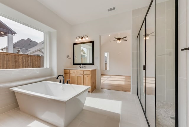 bathroom with a stall shower, a soaking tub, vanity, and visible vents