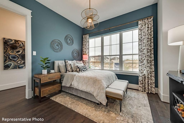 bedroom featuring lofted ceiling, dark wood-style floors, and baseboards