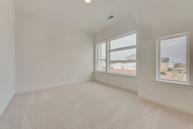 empty room with light carpet, baseboards, and visible vents