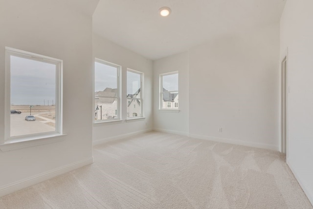 spare room featuring carpet and baseboards