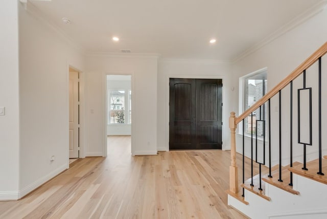 foyer entrance featuring stairs, baseboards, crown molding, and wood finished floors