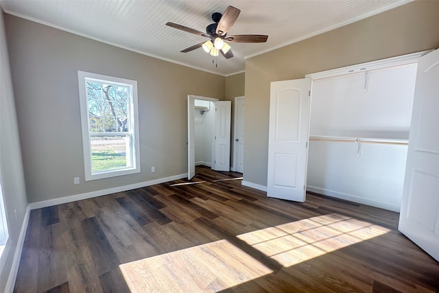 unfurnished bedroom featuring ceiling fan, dark hardwood / wood-style flooring, crown molding, and a closet