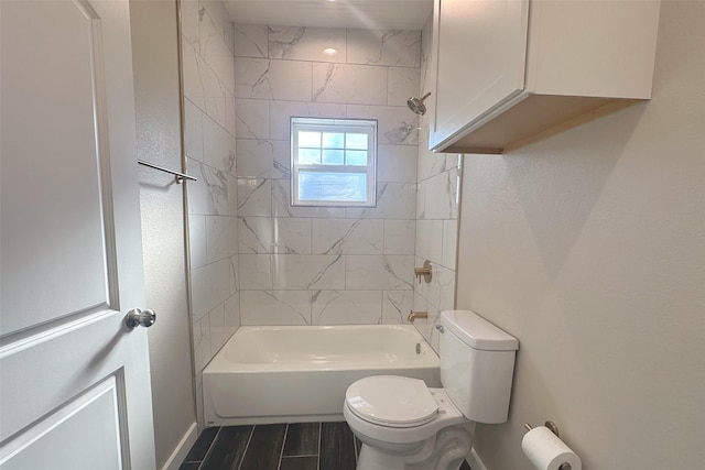 bathroom with tiled shower / bath combo and toilet