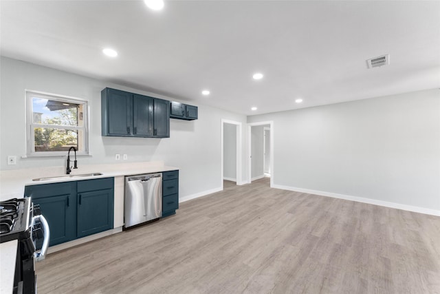 kitchen featuring a sink, light countertops, stainless steel dishwasher, gas range, and light wood-type flooring