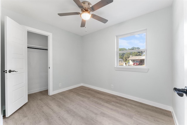 unfurnished bedroom featuring a closet, baseboards, light wood-style flooring, and a ceiling fan