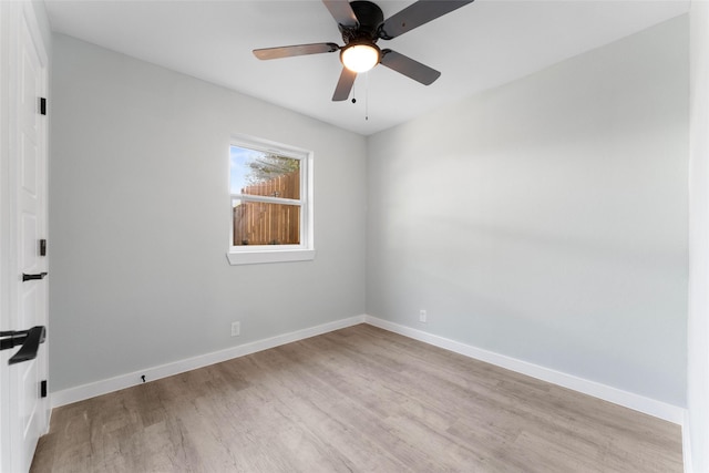 spare room featuring baseboards, light wood-style floors, and ceiling fan