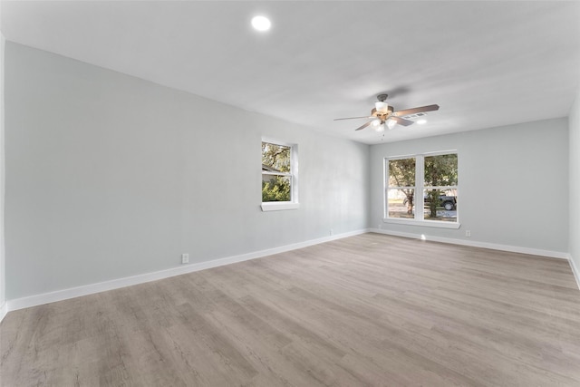 empty room with light wood-type flooring, baseboards, and a ceiling fan