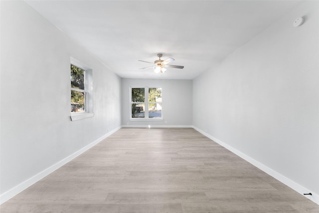 spare room with light wood-style flooring, baseboards, and ceiling fan