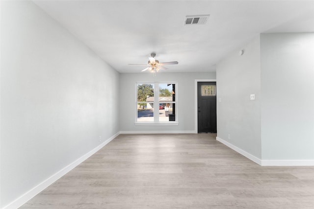 empty room with visible vents, baseboards, ceiling fan, and light wood finished floors