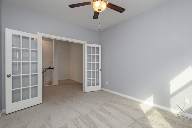 unfurnished room with ceiling fan, french doors, and carpet