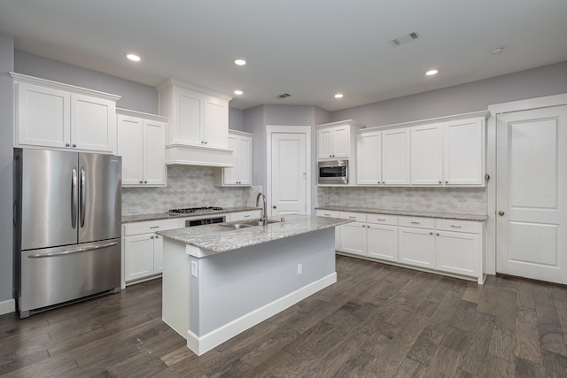 kitchen featuring dark wood-type flooring, white cabinets, decorative backsplash, sink, and appliances with stainless steel finishes