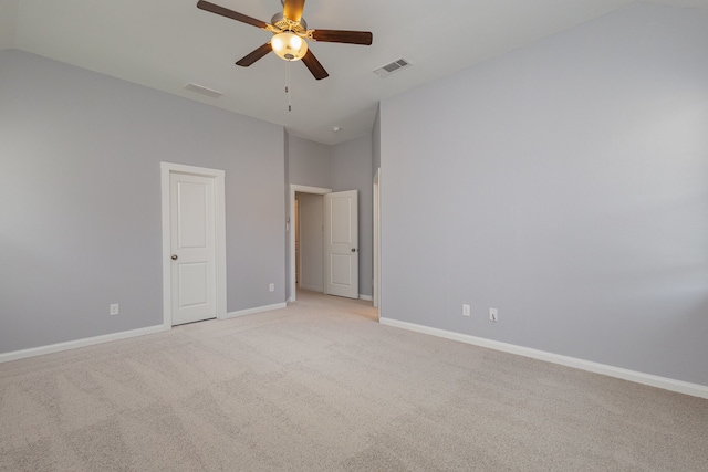 unfurnished bedroom featuring vaulted ceiling, light carpet, and ceiling fan