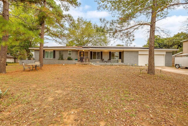 single story home featuring a porch and a garage