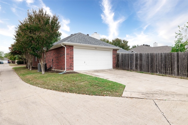 view of side of home featuring a lawn and a garage