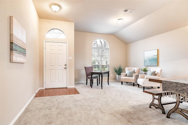 entryway with vaulted ceiling, carpet floors, and a notable chandelier