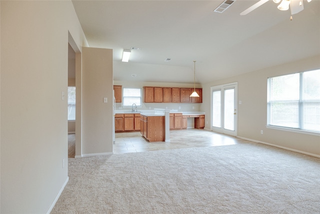 kitchen with light colored carpet, ceiling fan, decorative light fixtures, and sink