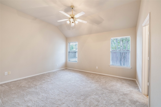 unfurnished room with ceiling fan, a healthy amount of sunlight, light carpet, and vaulted ceiling