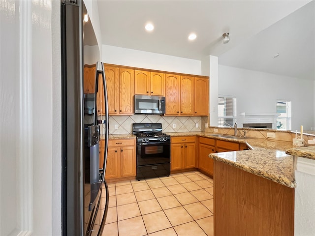 kitchen featuring stainless steel appliances, light tile patterned floors, light stone countertops, decorative backsplash, and kitchen peninsula