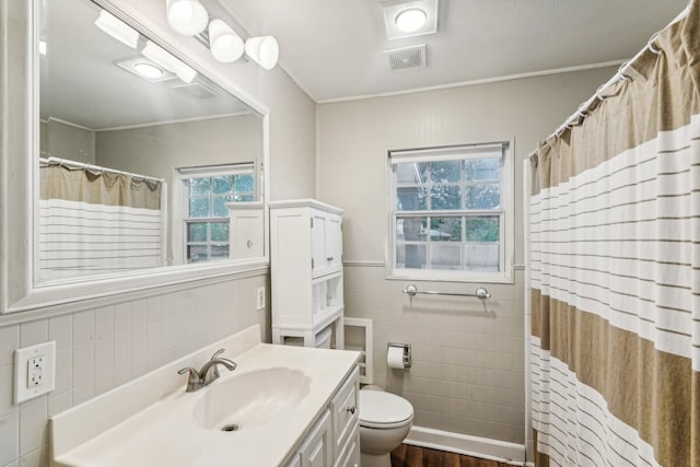 bathroom featuring hardwood / wood-style flooring, toilet, curtained shower, tile walls, and vanity