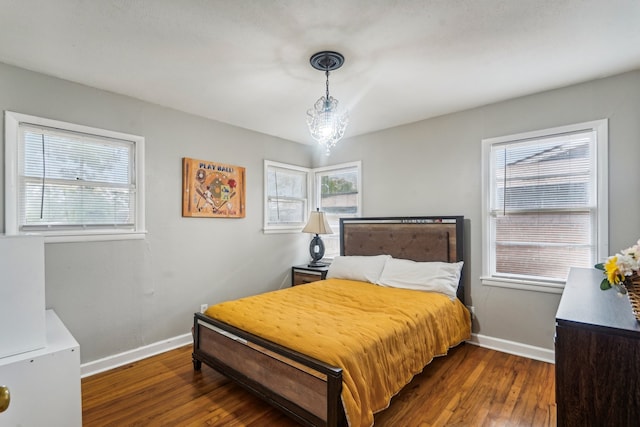 bedroom with a notable chandelier and dark hardwood / wood-style floors